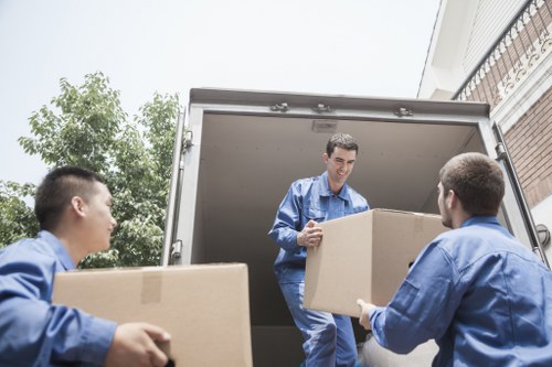 Removal team carrying a sofa through a Tooting townhouse
